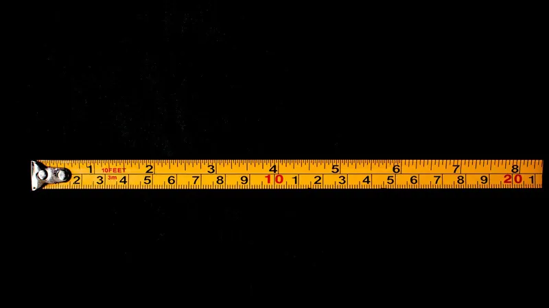 Cinta métrica amarilla en primer plano sobre fondo negro, símbolo del cálculo de distancia en fototerapia