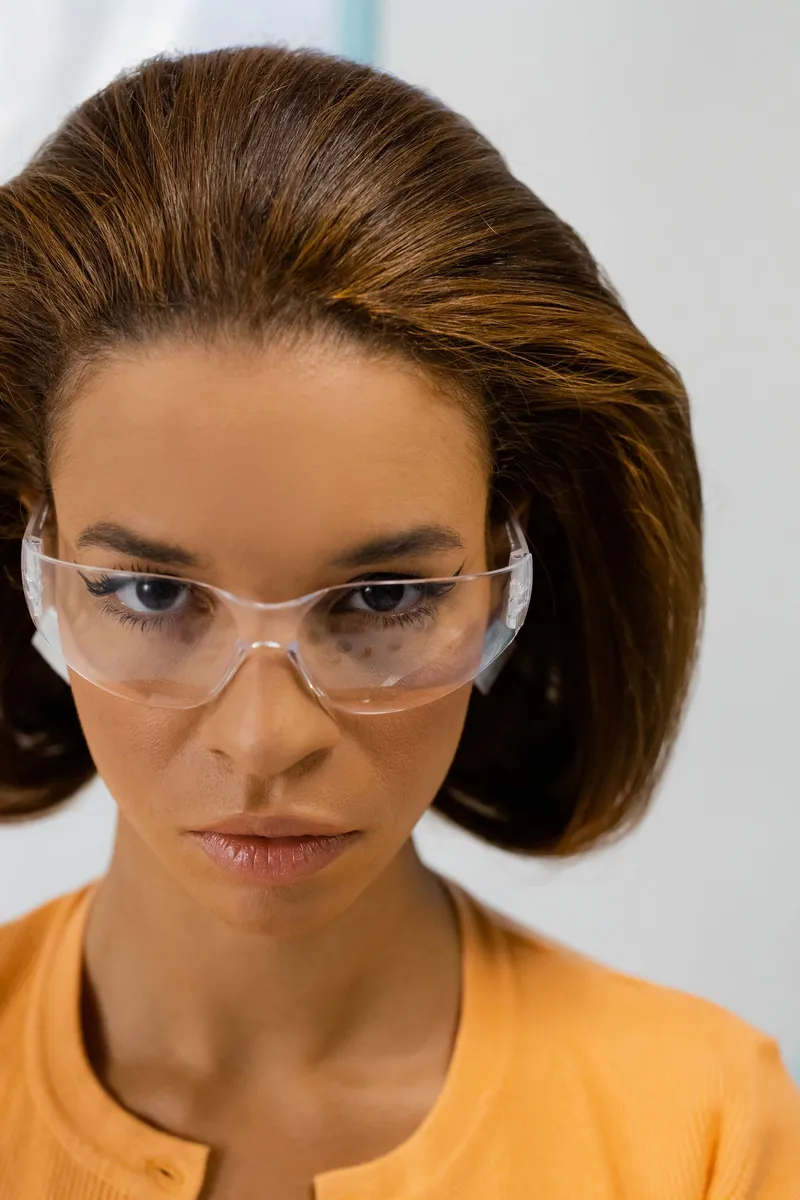 Mujer con top naranja llevando gafas de protección
