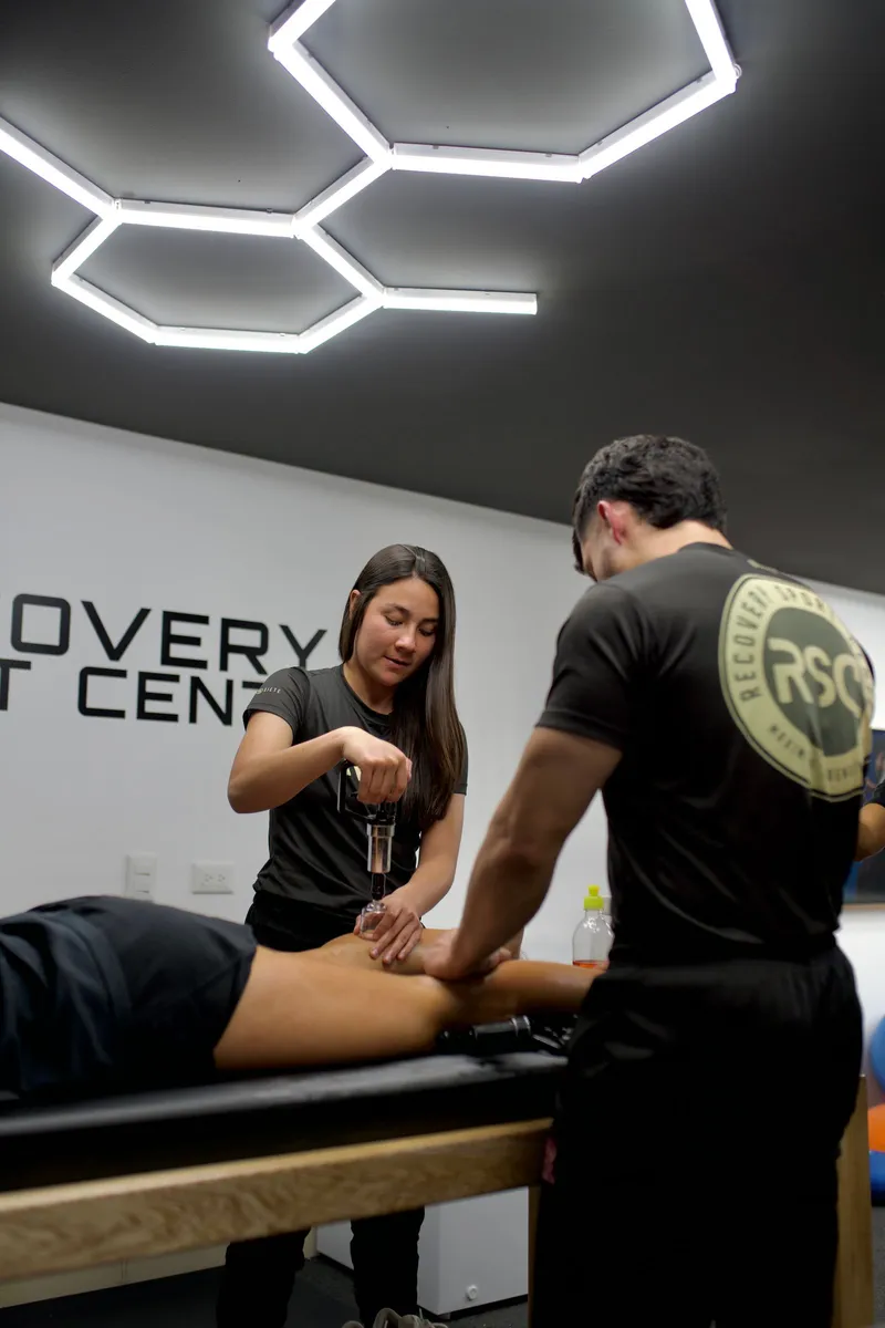 Fisioterapeutas realizando un tratamiento con equipo especializado en una clínica